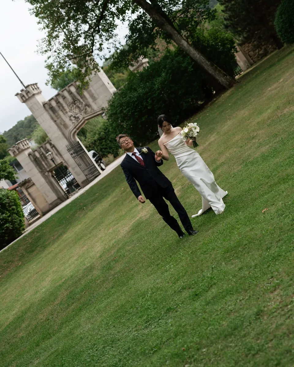 Newlyweds walking across the castle lawn