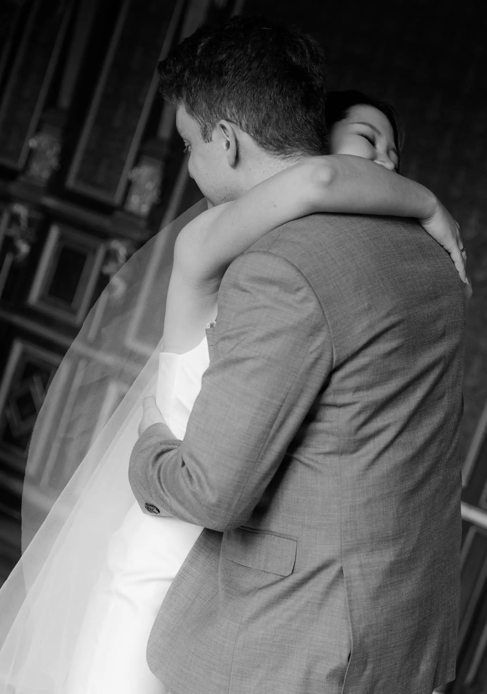 Black and white photo of the bride hugging the groom