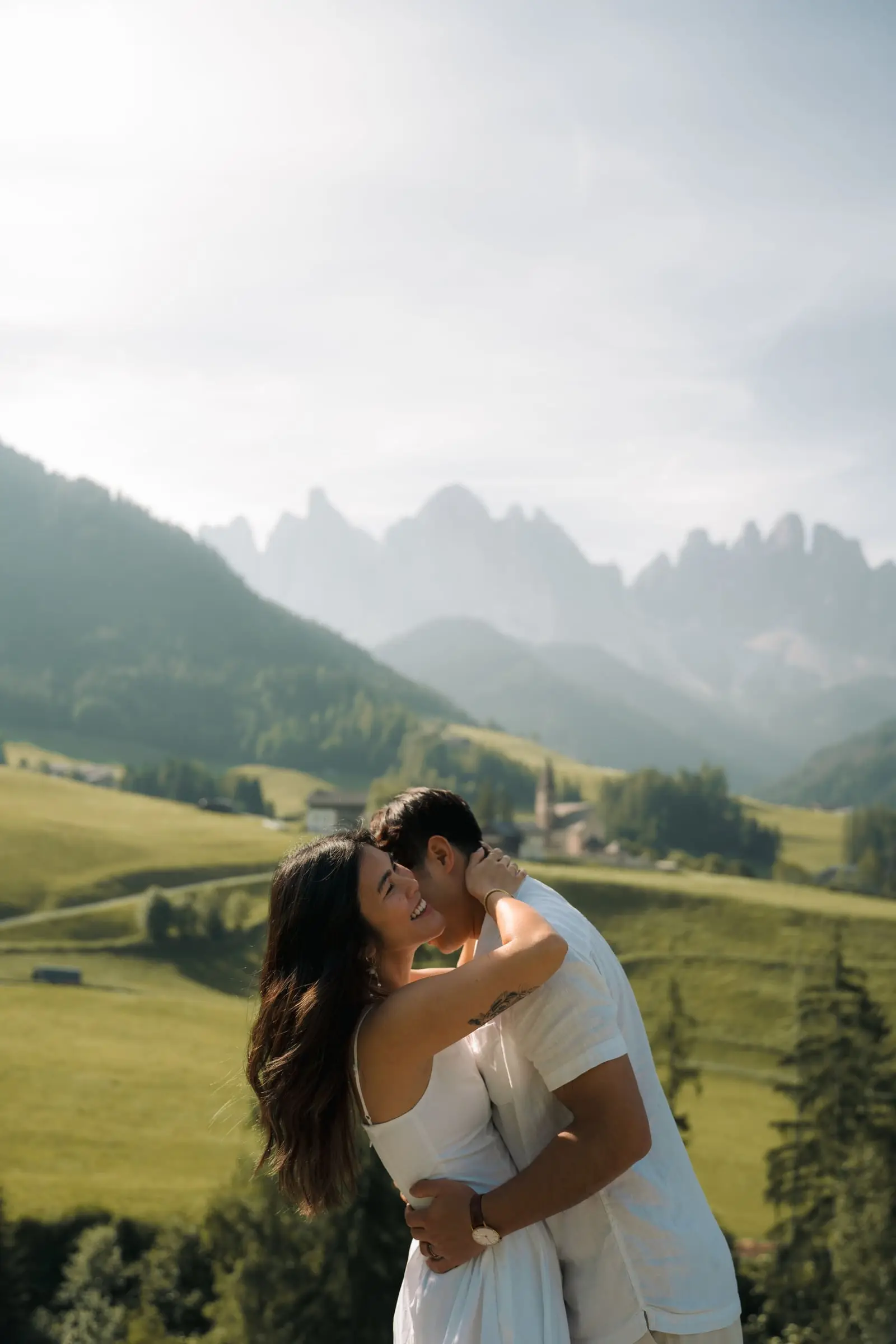 Couple embracing above the valley with the Odle peaks behind