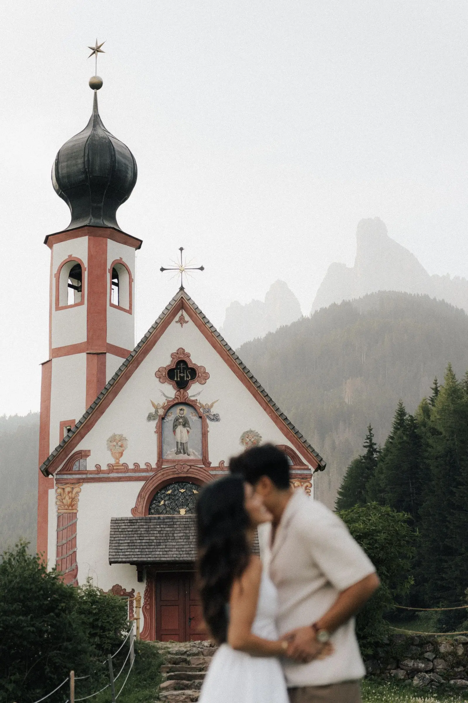 Couple kissing in front of St. John's Chapel in Ranui