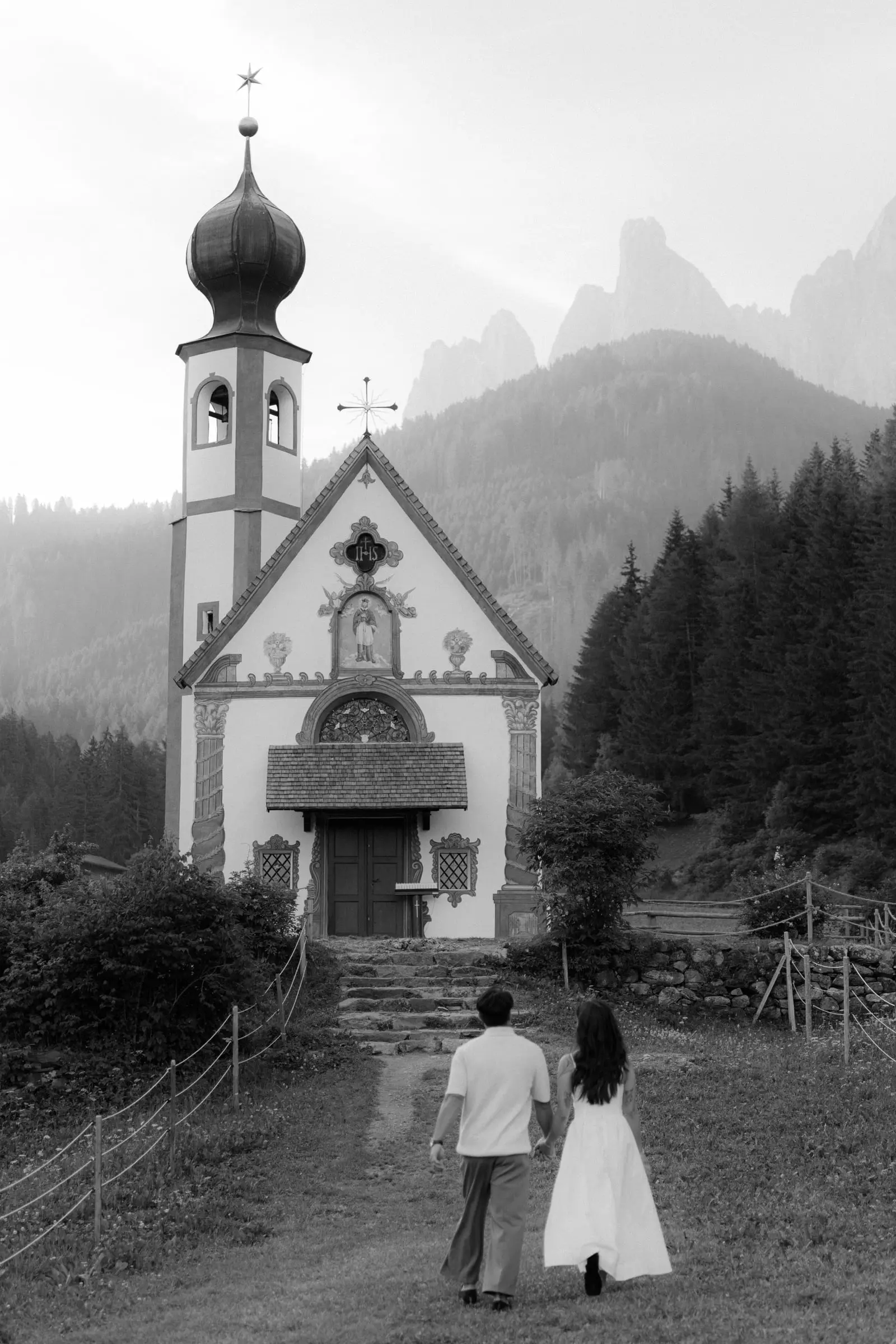 Black and white photo of the couple walking to St. John's Chapel