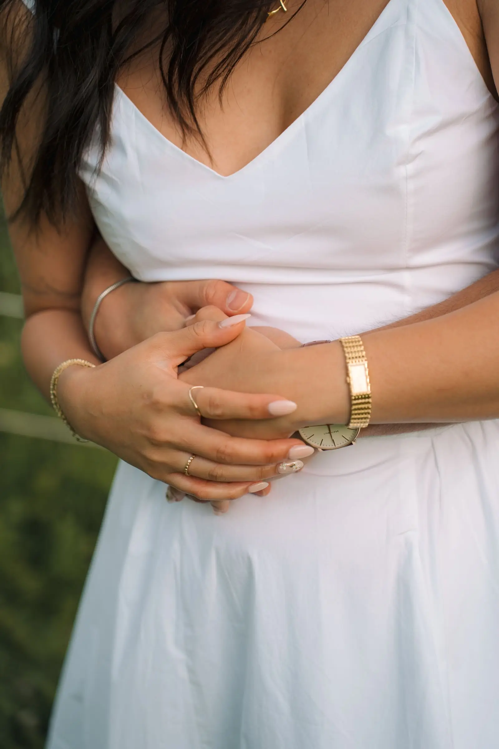 Close-up of his arms wrapped around her waist, her hands on his