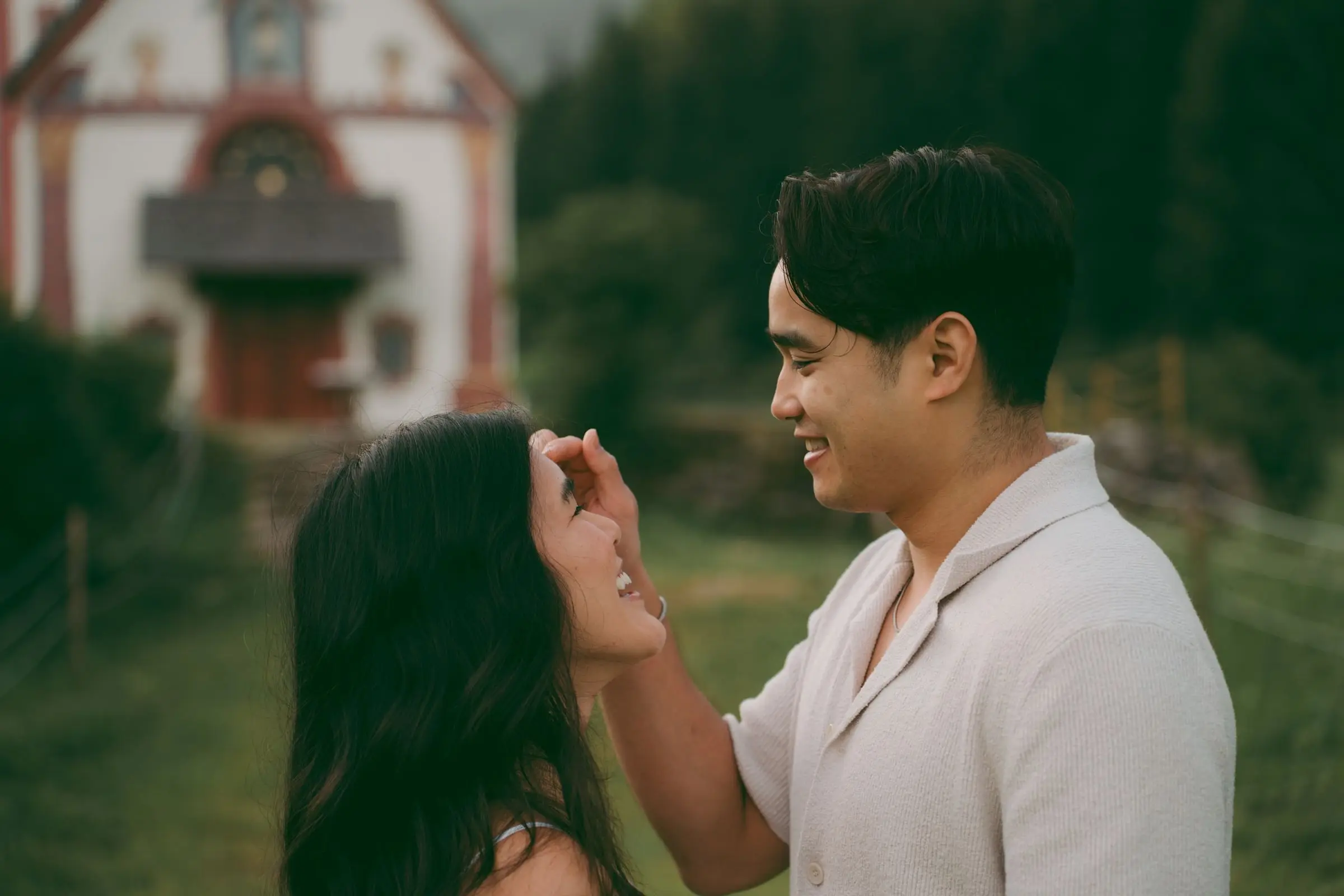 He brushes her hair from her face near the chapel